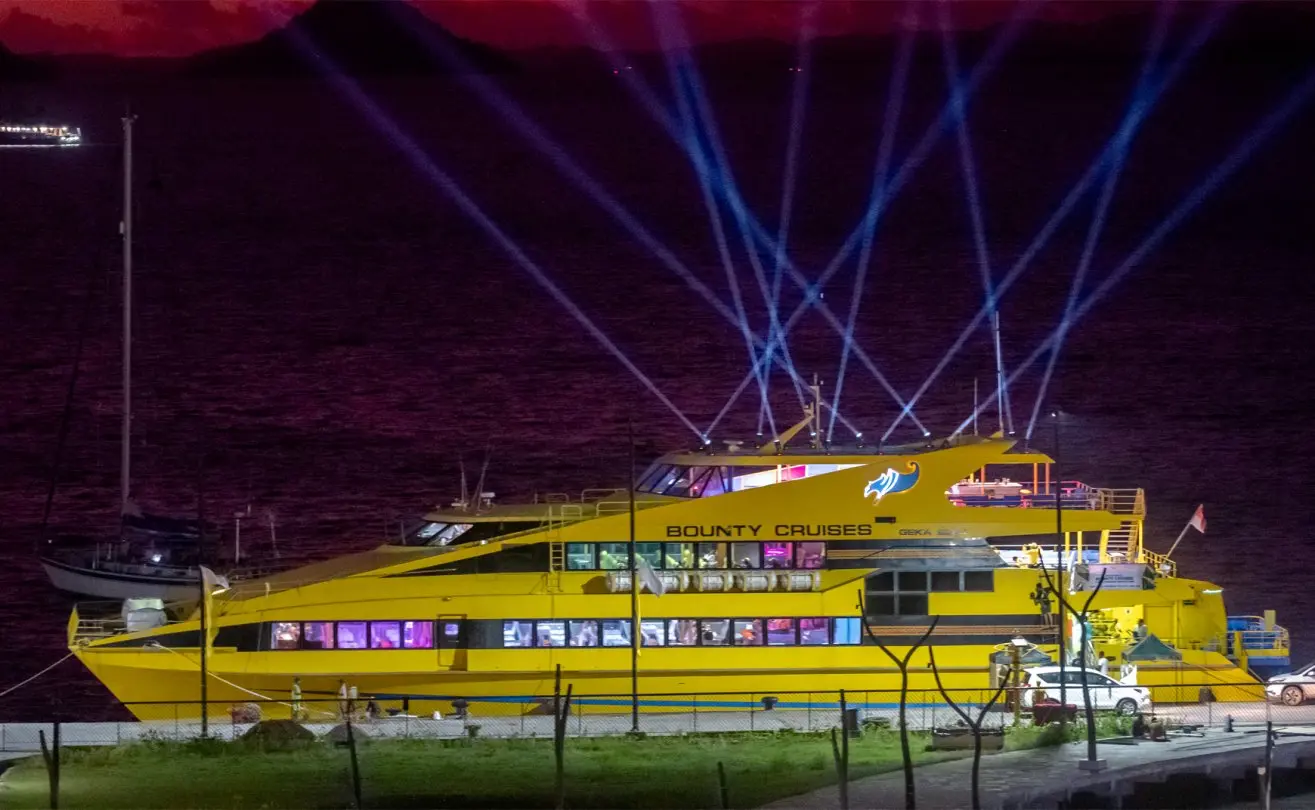 The yellow Bounty Cruises ship lit up at night for a Bali sunset dinner cruise